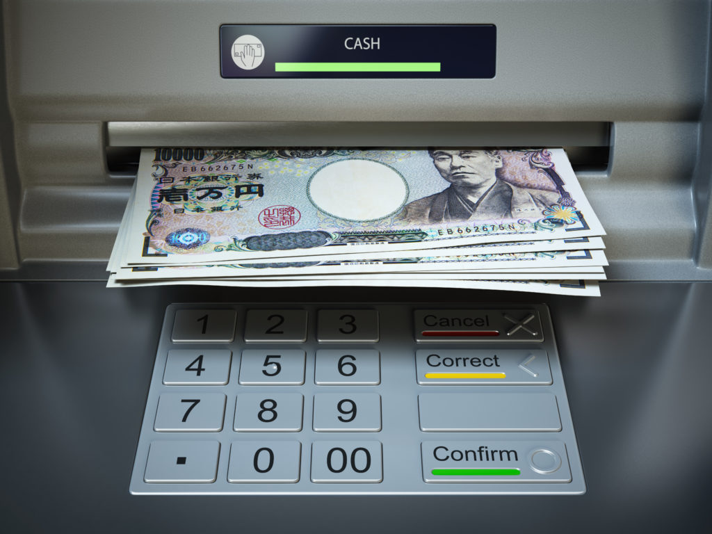 ATM machine and money. Withdrawing yen banknotes.