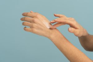 woman-applying-protective-cream-on-dry-skin-of-han-8UPQS5E
