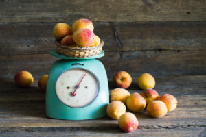 Apricots with kitchen scales on a wood background. toning. Vegetarian food. Healthy life.